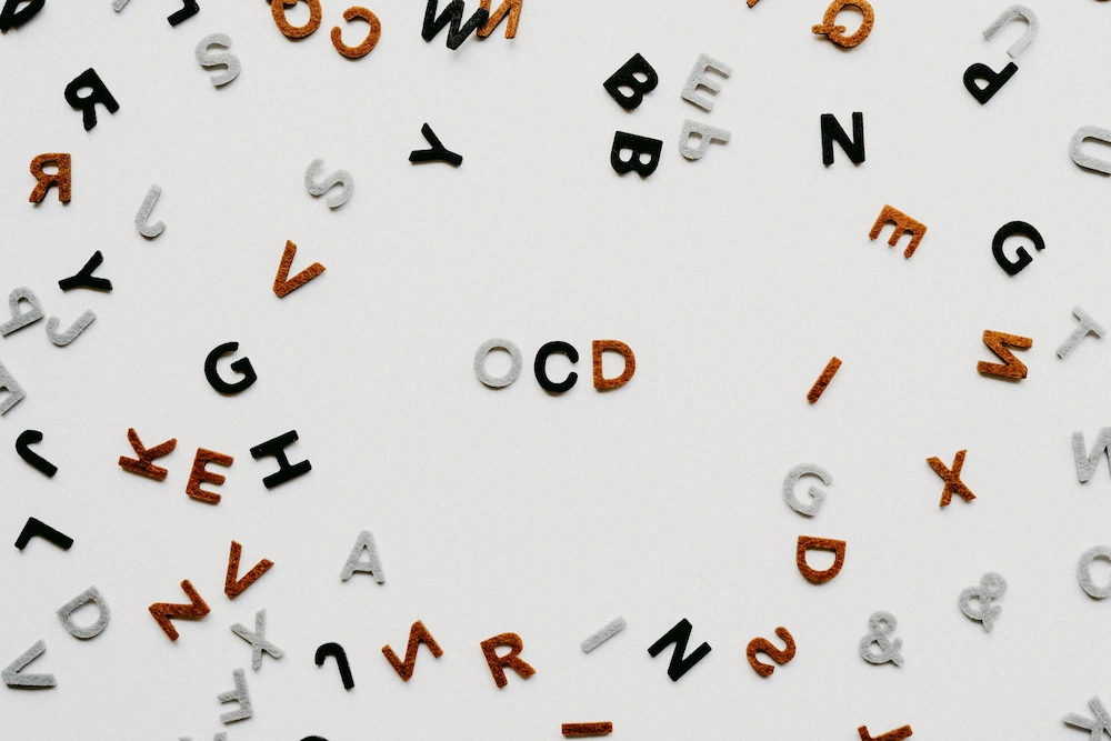 Letters arranged randomly on a table with the letters O, C, and D in the middle