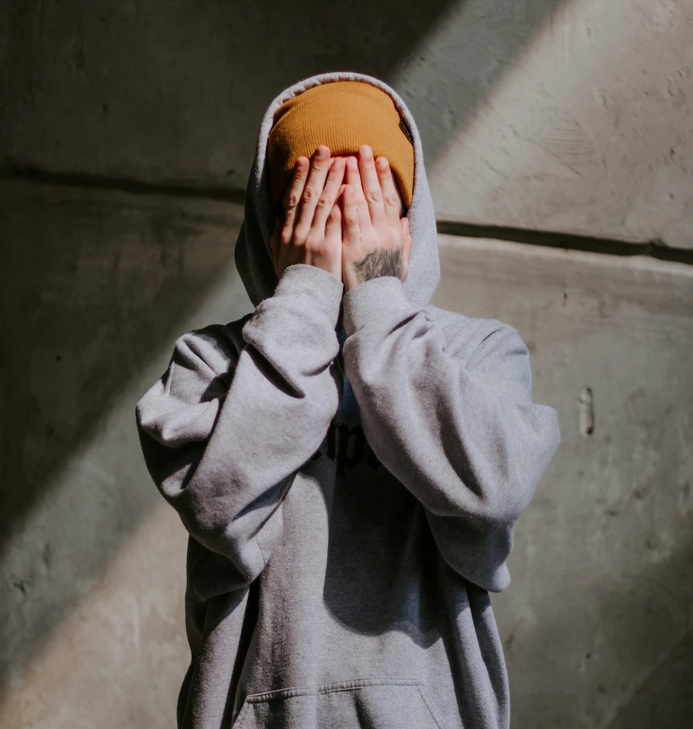 Person with hands covering face
